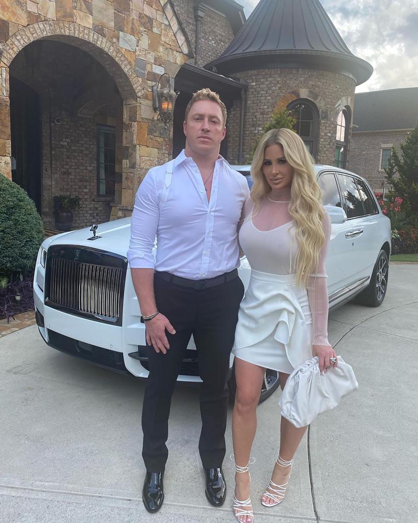 kim zolciak and kroy biermann standing in front of their rolls royce