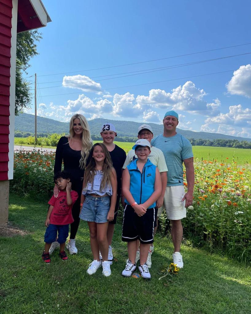 kim zolciak, kroy biermann and their kids standing in front of a field of wildflowers