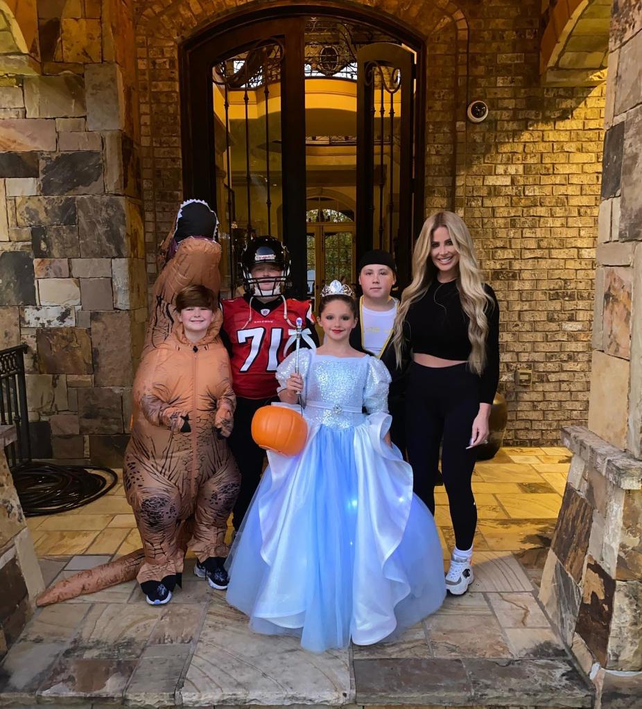 kim zolciak and her four young kids dressed up for halloween standing in front of their front door