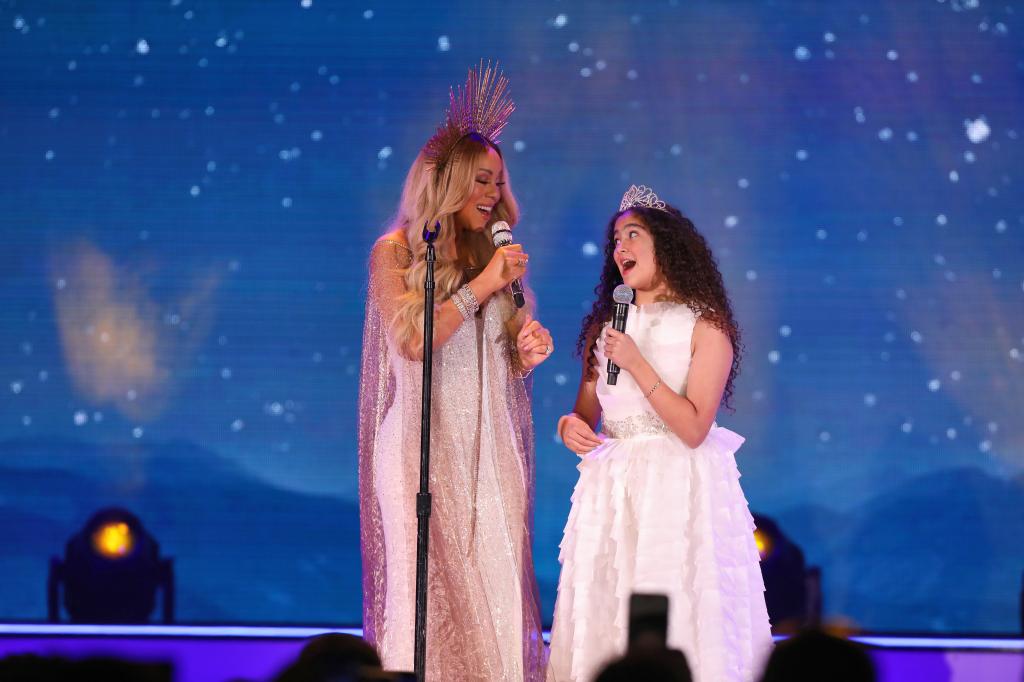 Mariah Carey and her daughter, Monroe Cannon, performing at a holiday concert.