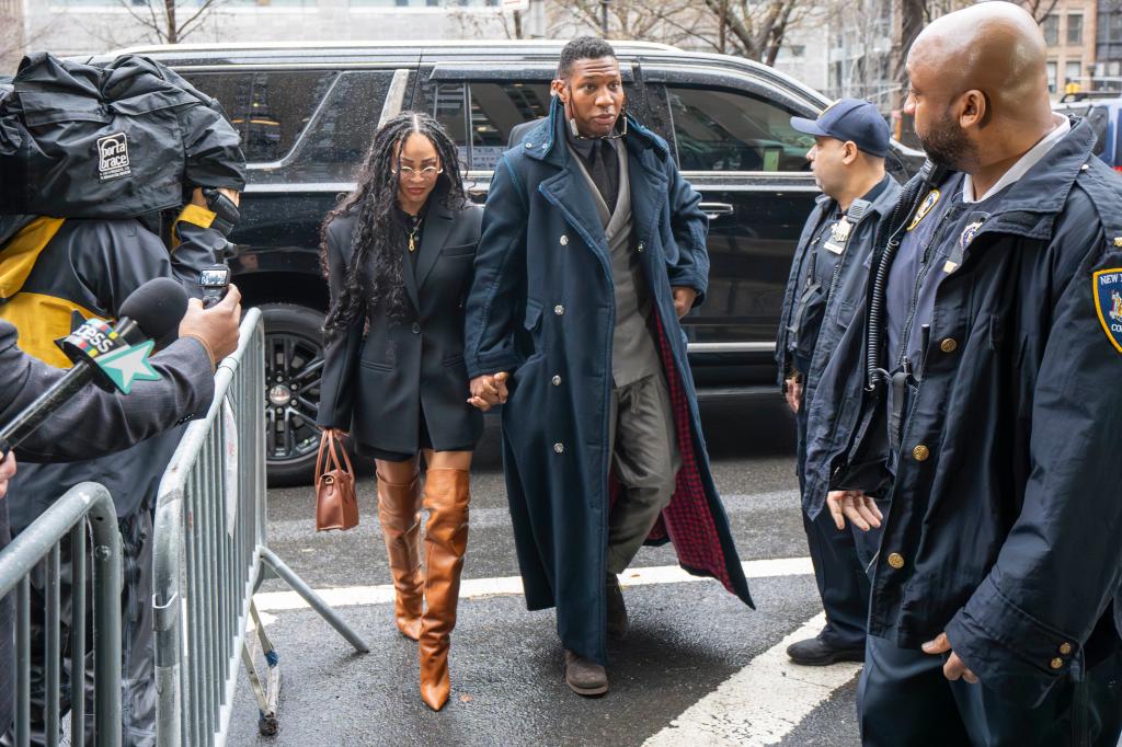 Meagan Good and Jonathan Majors holding hands