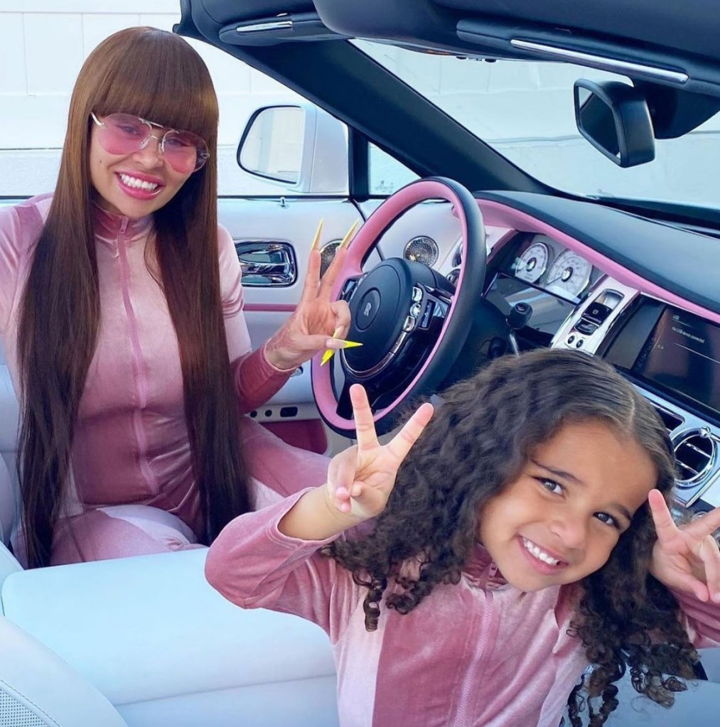 blac chyna and dream kardashian matching in pink sweatsuits holding up peace sign fingers