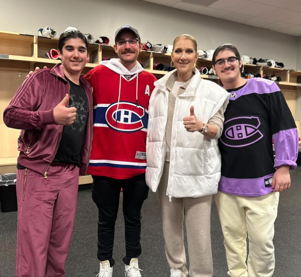 Celine Dion posing with her sons backstage at a hockey game