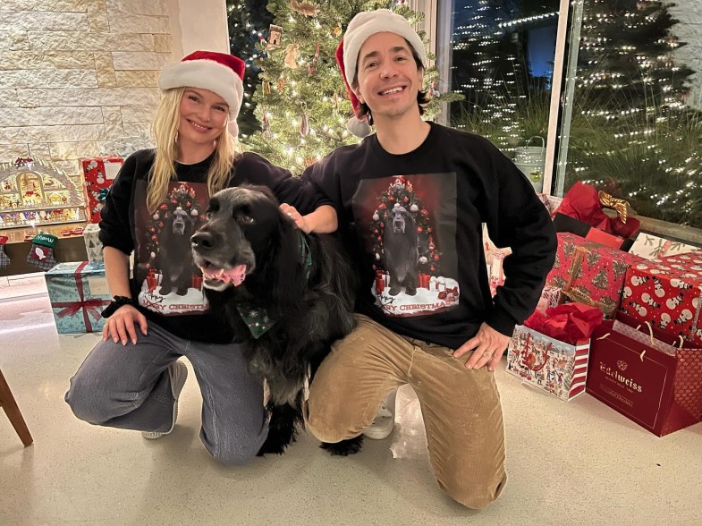 Kate Bosworth and Justin Long with their dog in front of a christmas tree