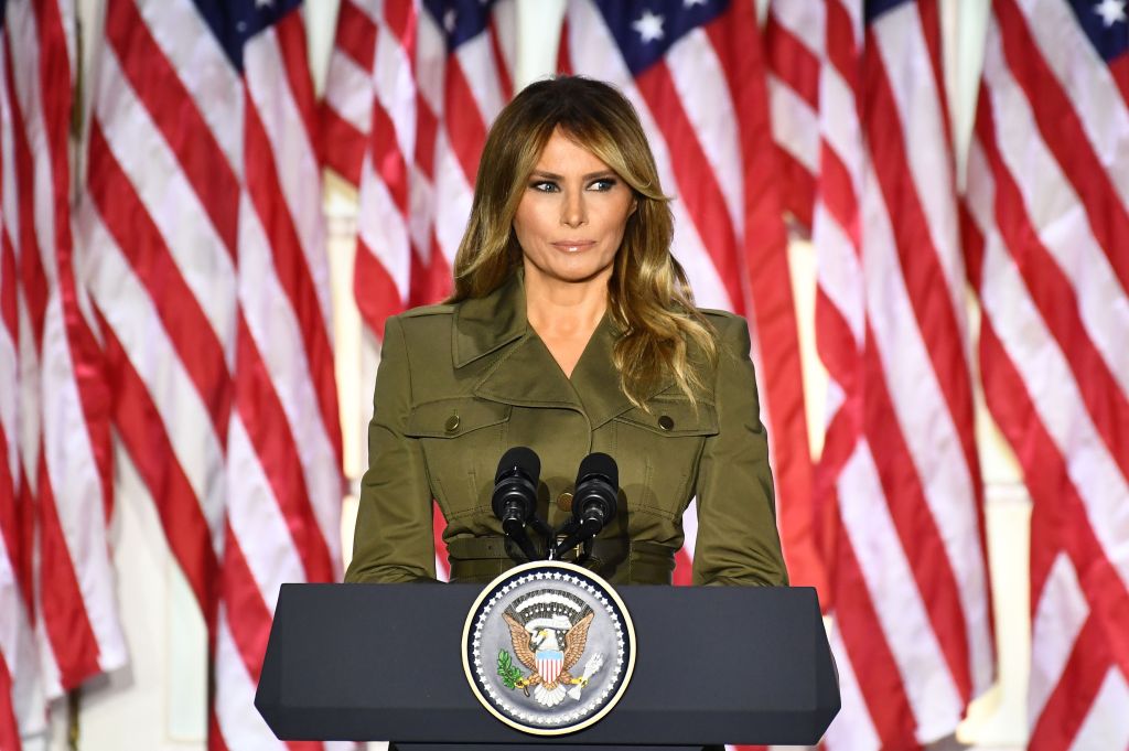 first lady melania trump standing at a podium with the US seal