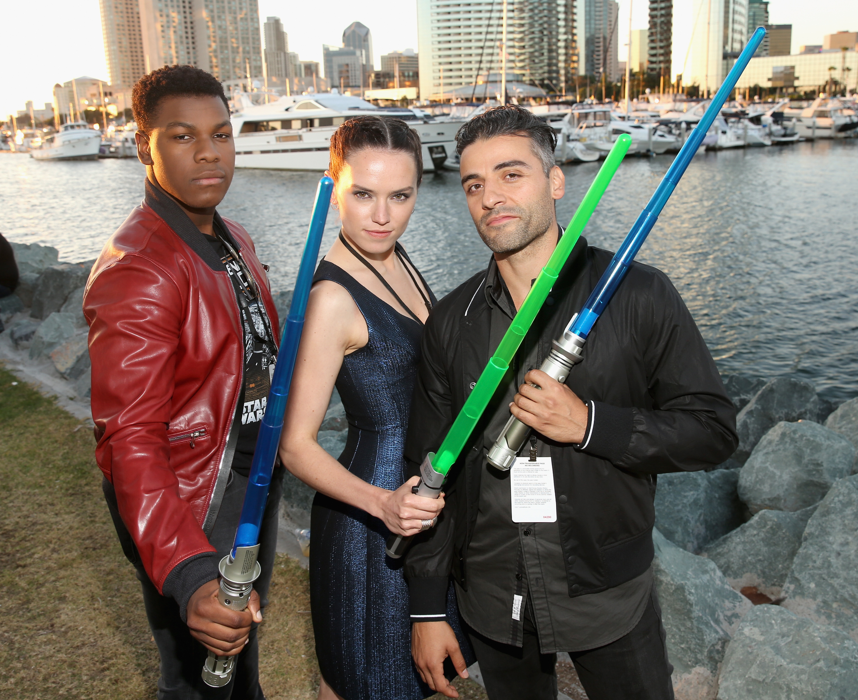 Actors John Boyega, Daisy Ridley and Oscar Isaac posing at a "Star Wars" event.