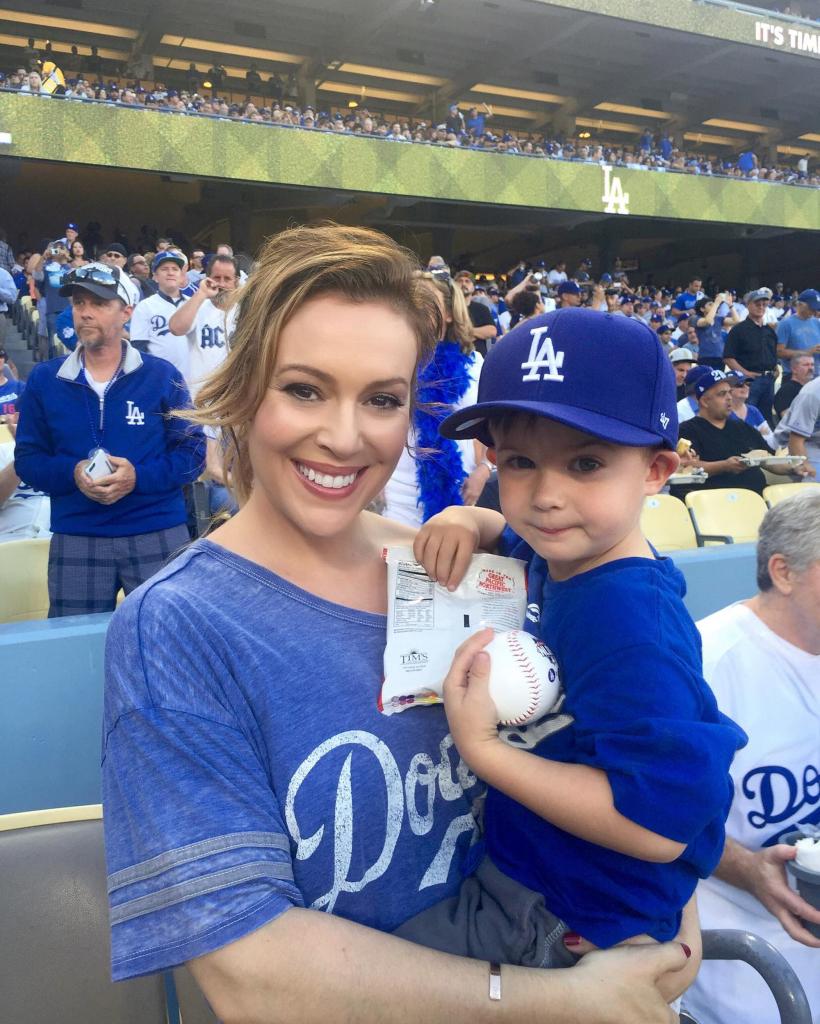 alyssa milano carrying her son at a dodgers game