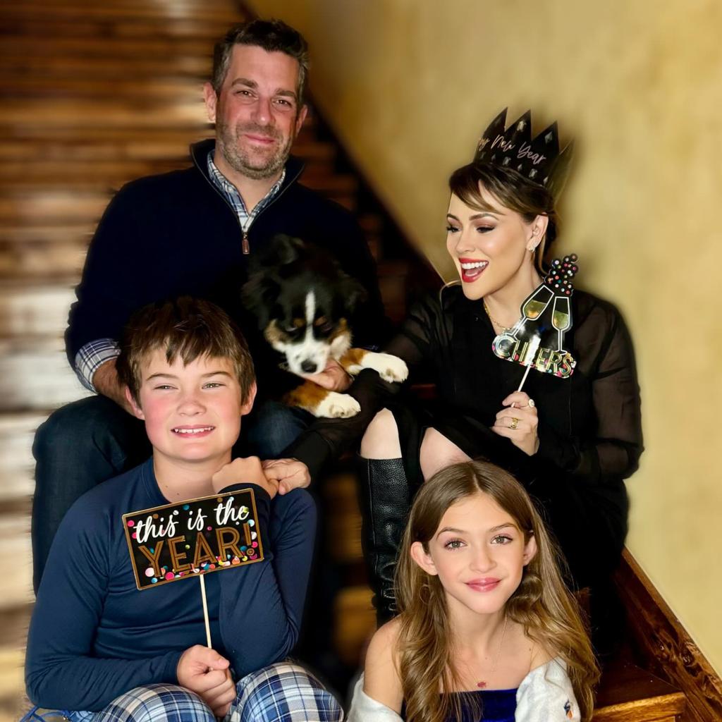 alyssa milano, dave bugliari and their two children sitting on steps with their dog