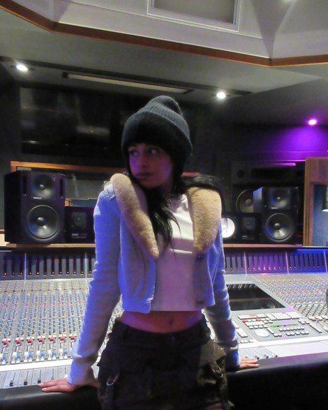 Camila Cabello leaning against a sound board