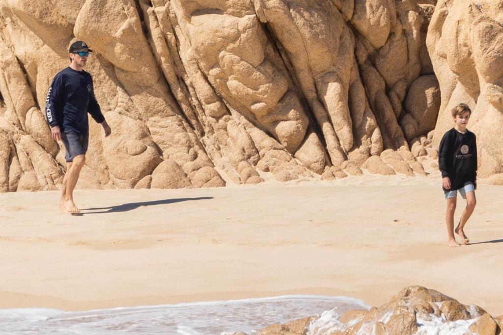 Christian Bale and his son on the beach.