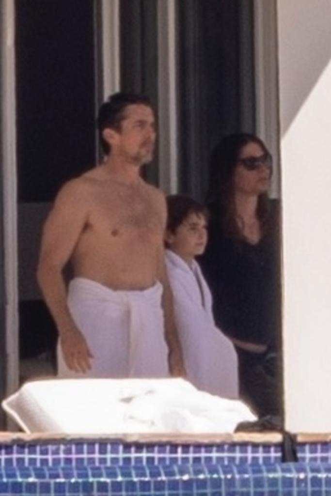 Christian Bale with a towel around his waist with his son
