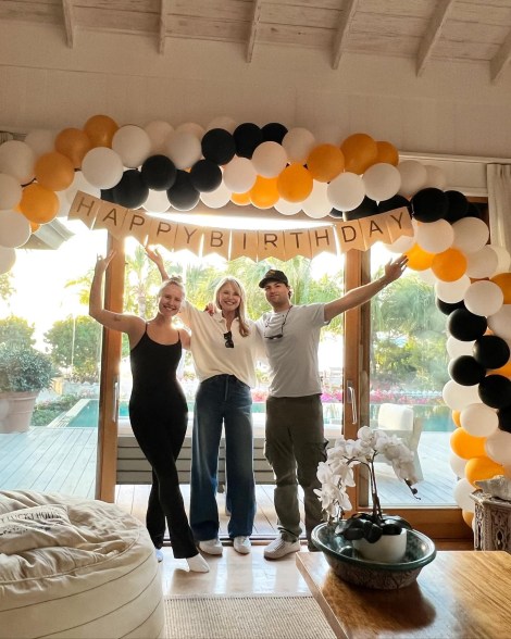 christie brinkley with sailor and jack posing underneath a balloon arch