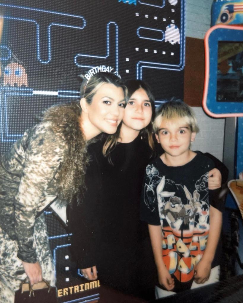 Kourtney Kardashian posing with Penelope Disick and Reign Disick