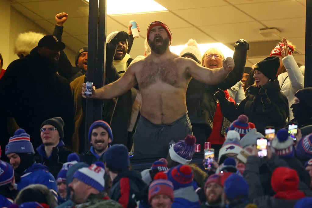 shirtless jason kelce screaming outside of a football stadium box