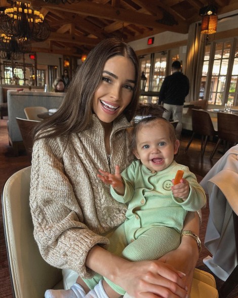 Olivia Culpo with a baby on her lap