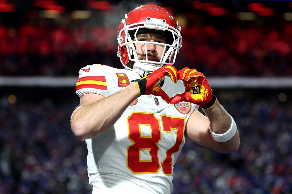 travis kelce in his football gear doing heart hands