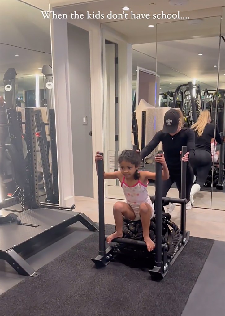 Khloe Kardashian pushes a sled-push as her daughter, True, stands on it.