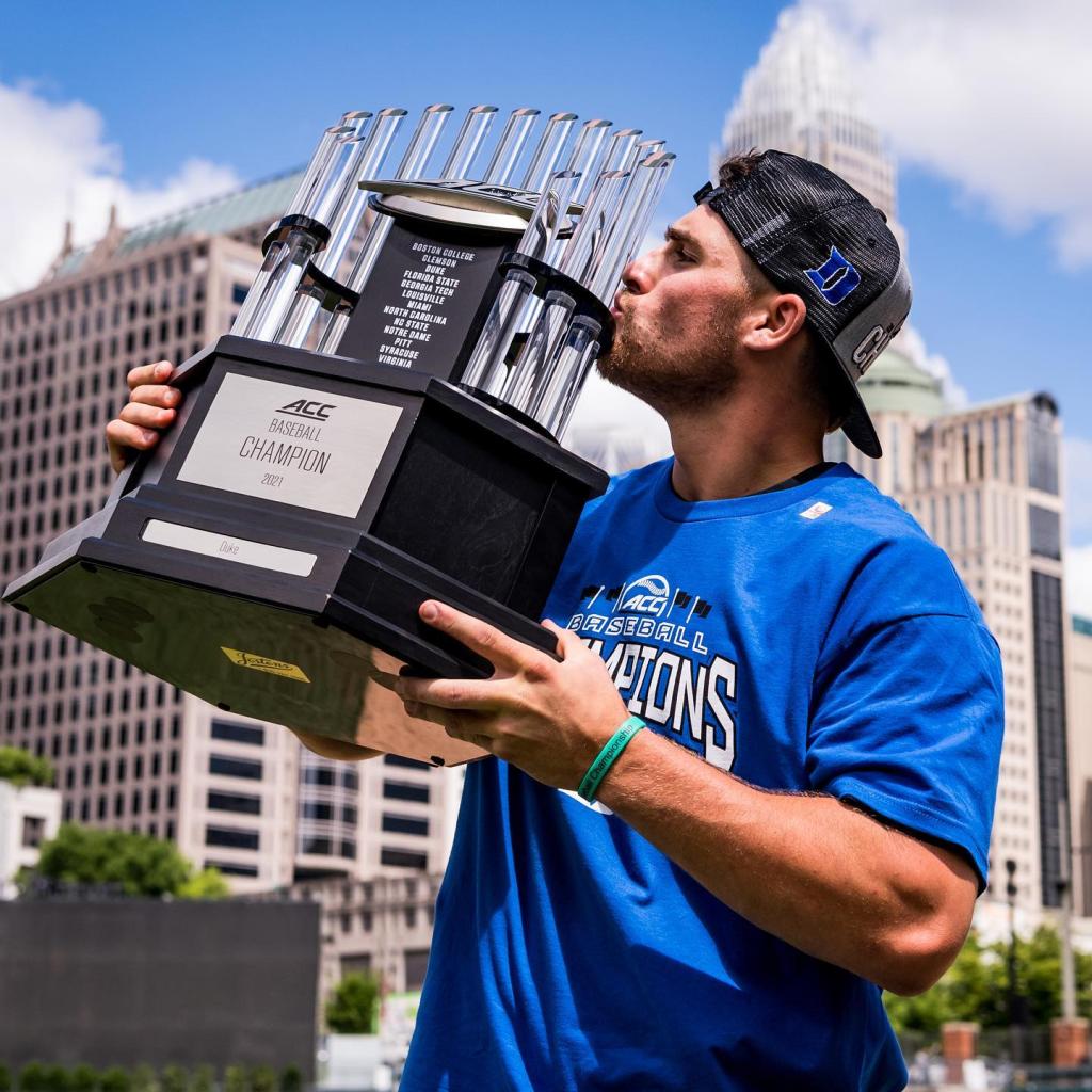 Billy Seidl kissing a baseball trophy