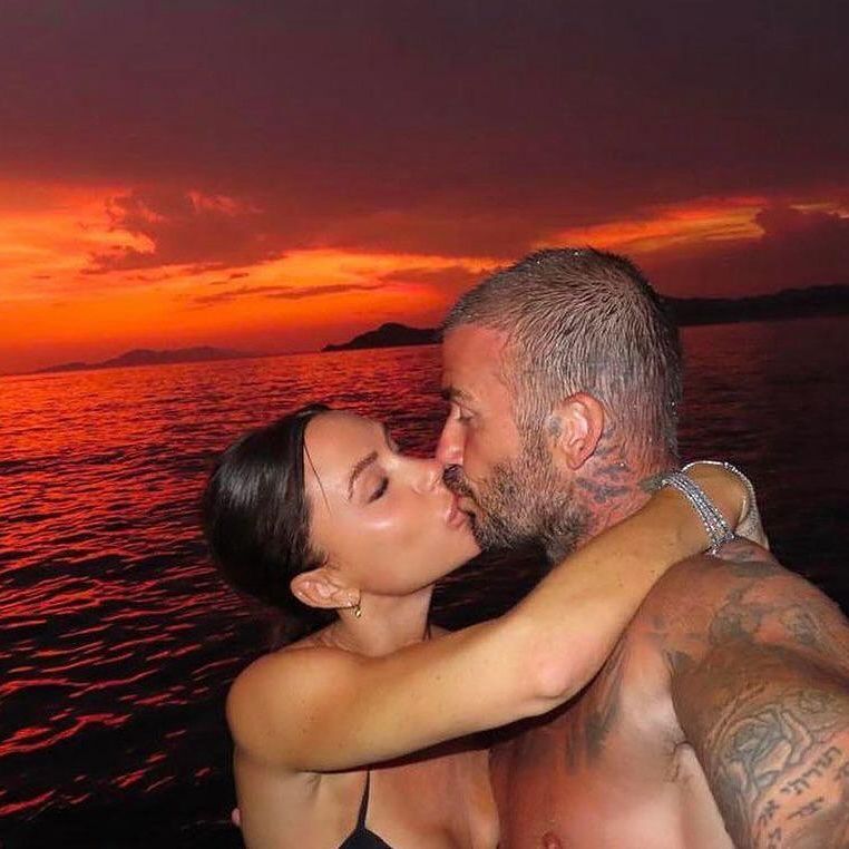 David and Victoria Beckham kiss in front of a gorgeous sunset at the beach.