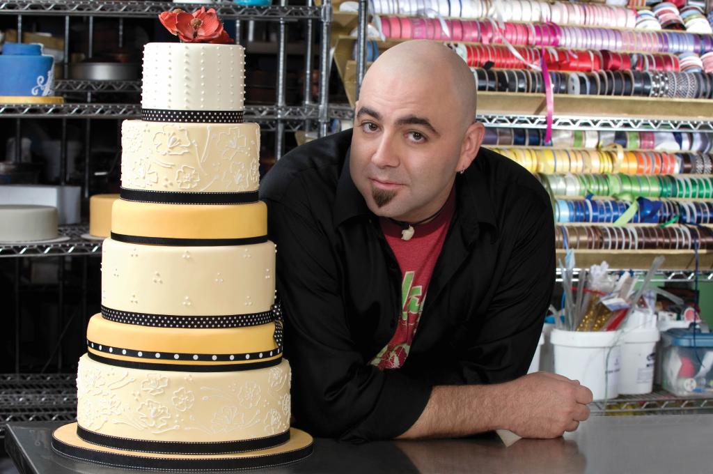 duff goldman next to a 6-tier cake