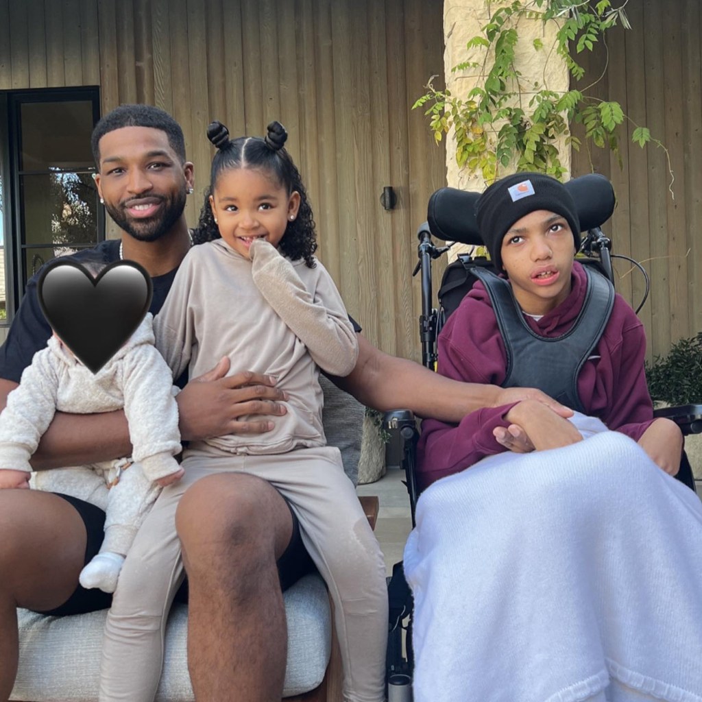 tristan thompson sitting with his daughter true and tatum on his lap next to amari who is in a wheelchair