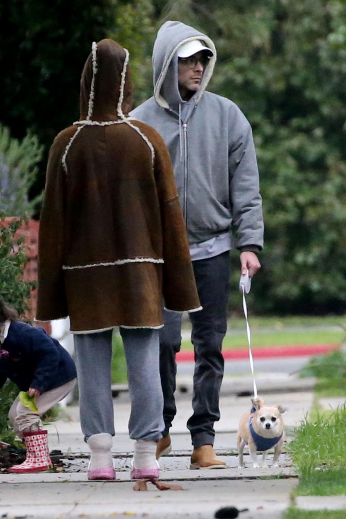 the back of alaia baldwin aronow facing her husband while walking their dog