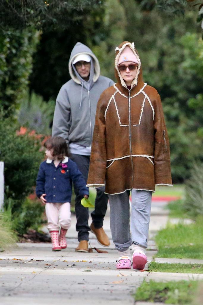 Alaia Baldwin Aronow walking with her husband and daughter