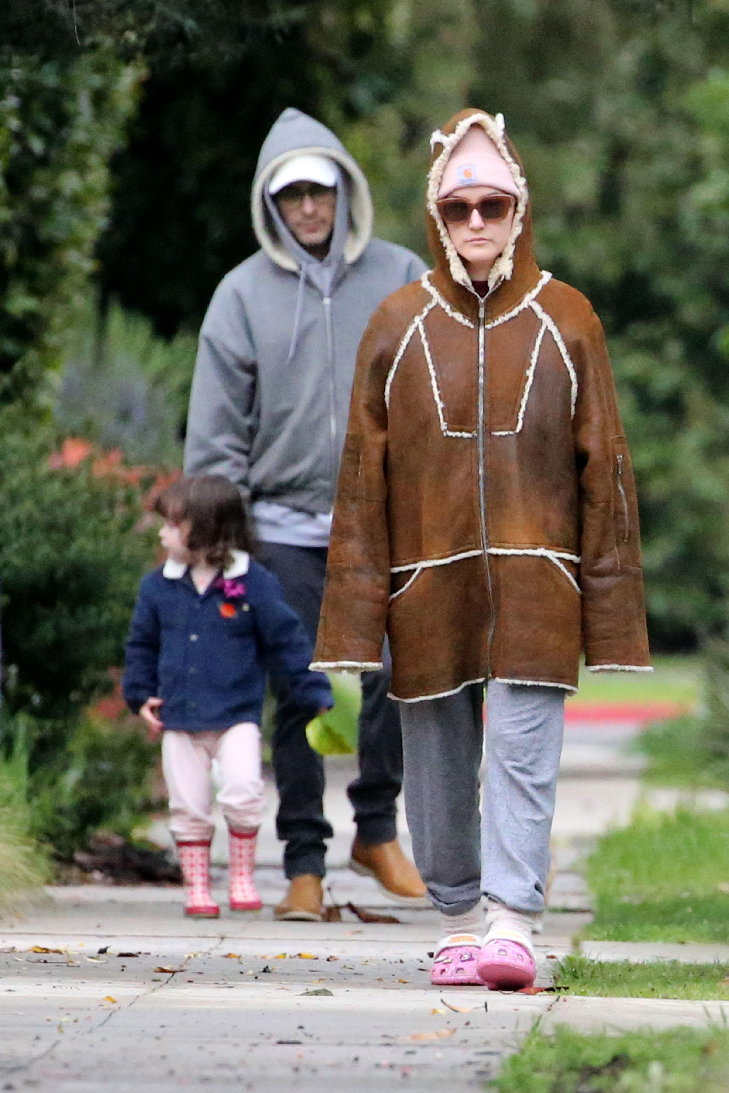 Alaia Baldwin Aronow walking with her husband and daughter