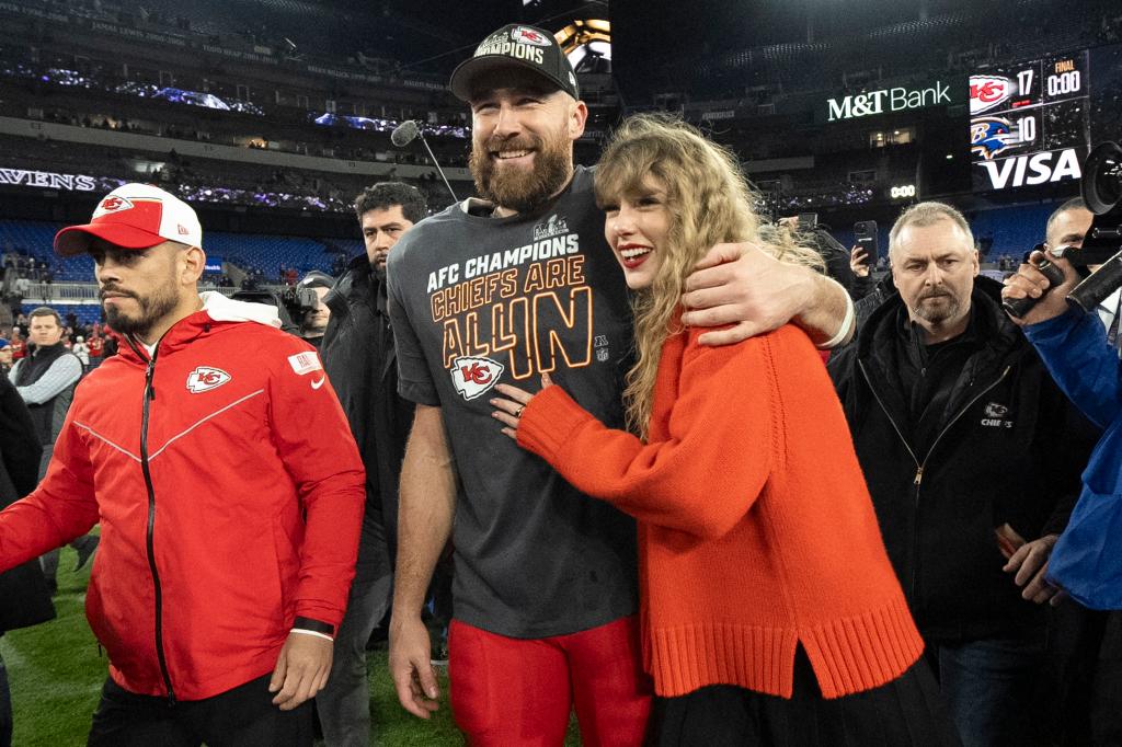 travis kelce with his arm wrapped around taylor swift on the football field