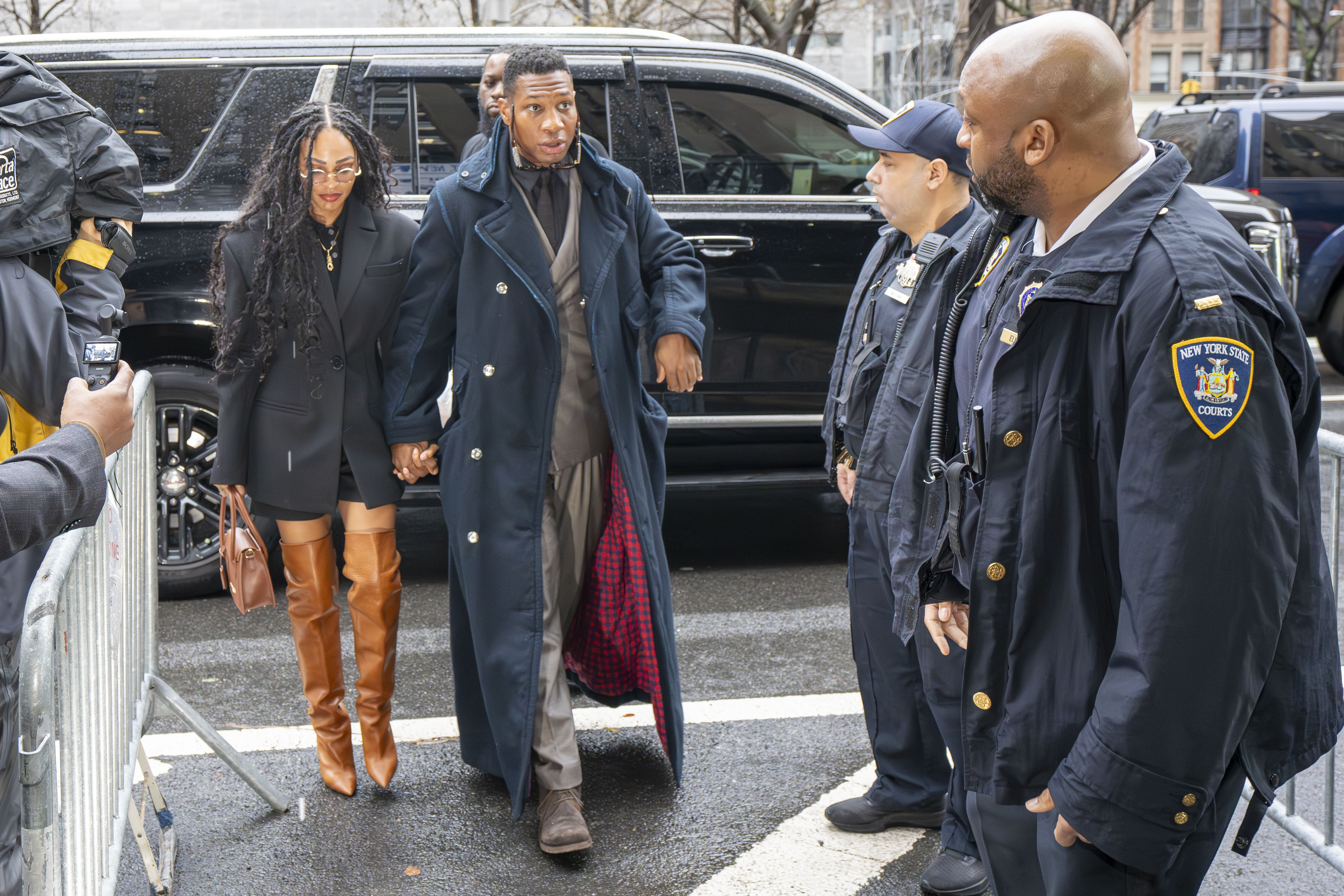 Meagan Good and Jonathan Majors arriving at trial.