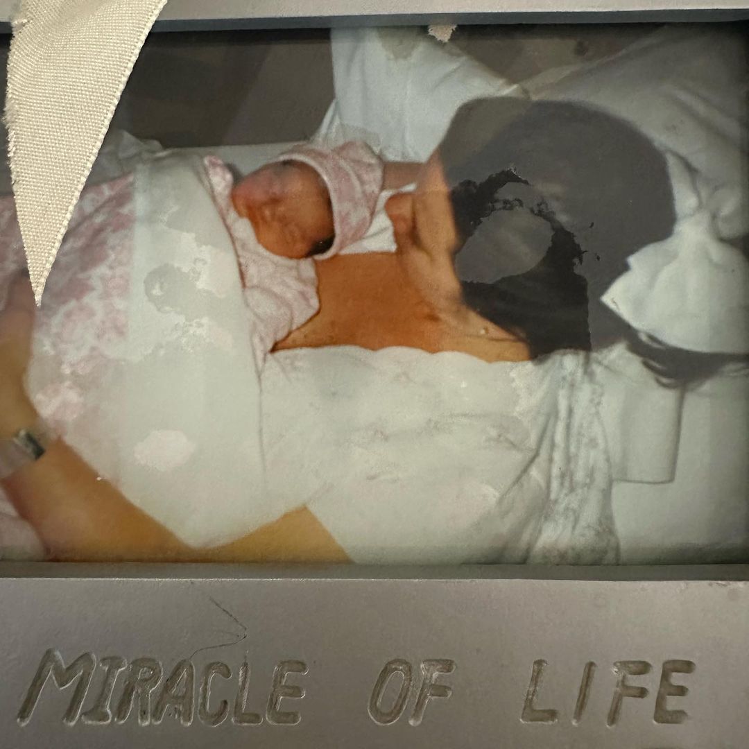 framed photo of karen houghton lying in bed holding her newborn