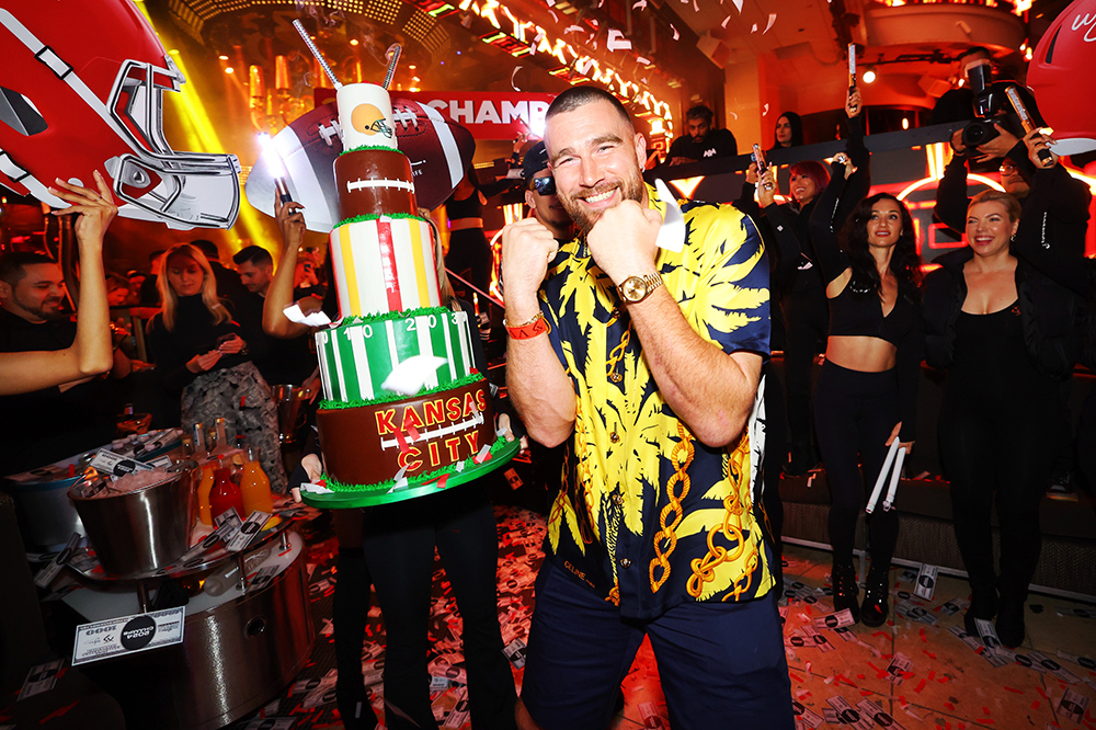 travis kelce partying next to a multi-tier cake