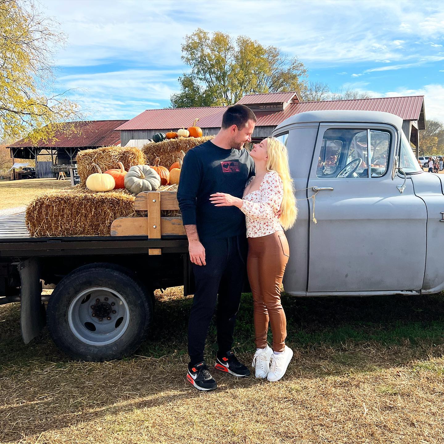 ariel winter and luke benward in front of a truck with pumpkins