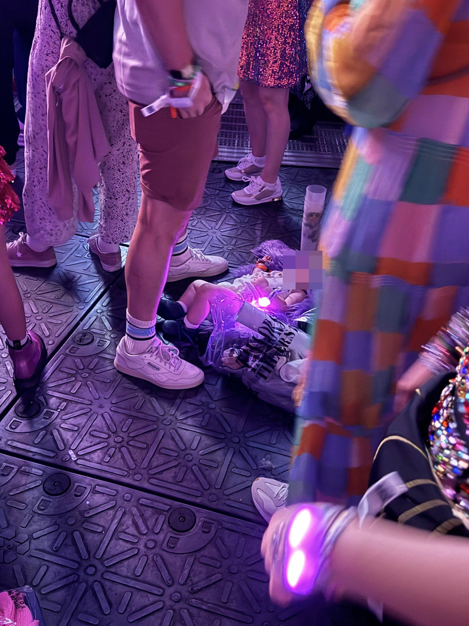 A baby on the floor of a Taylor Swift concert