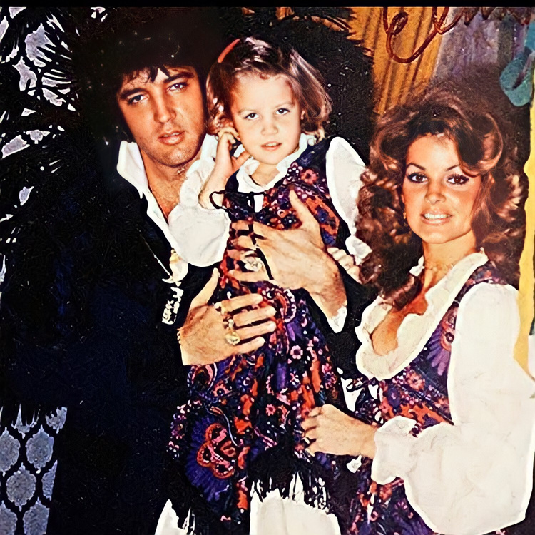 Elvis Presley holds Lisa Marie Presley alongside Priscilla Presley.