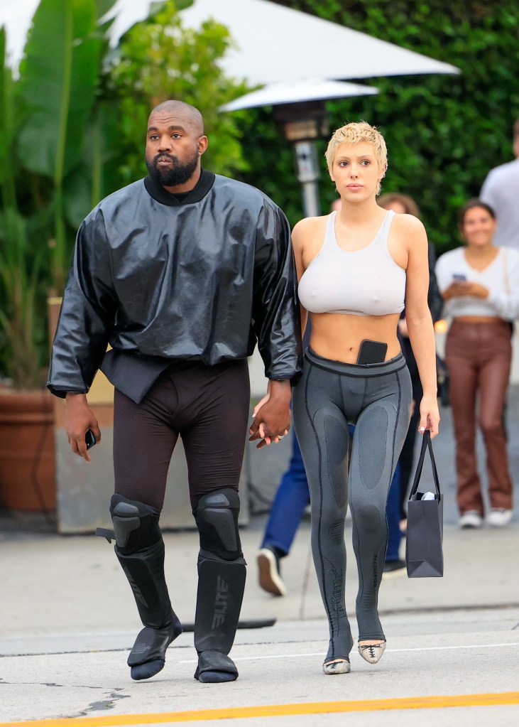 Bianca Censori and Kanye West holding hands. 