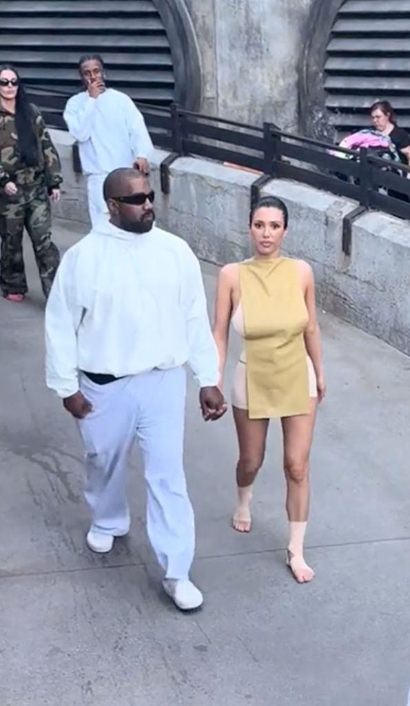 Kanye West and Bianca Censori holding hands. 