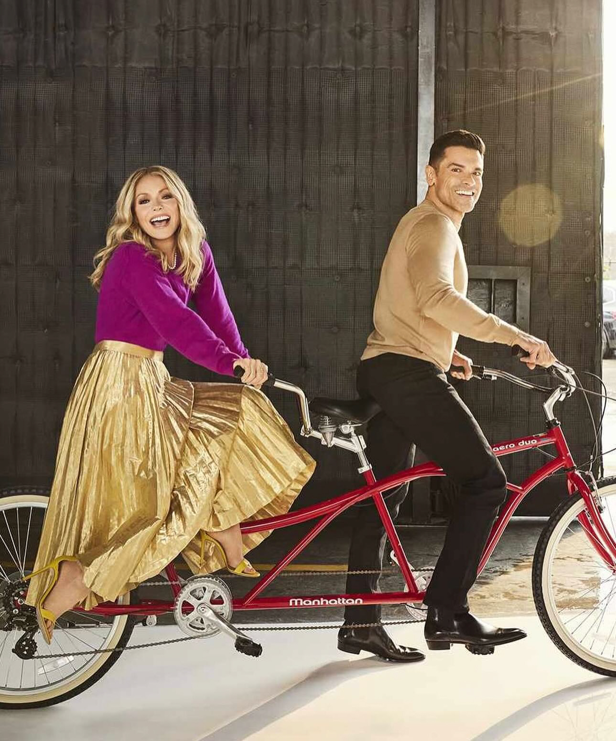 Kelly Ripa and Mark Consuelos riding a bike