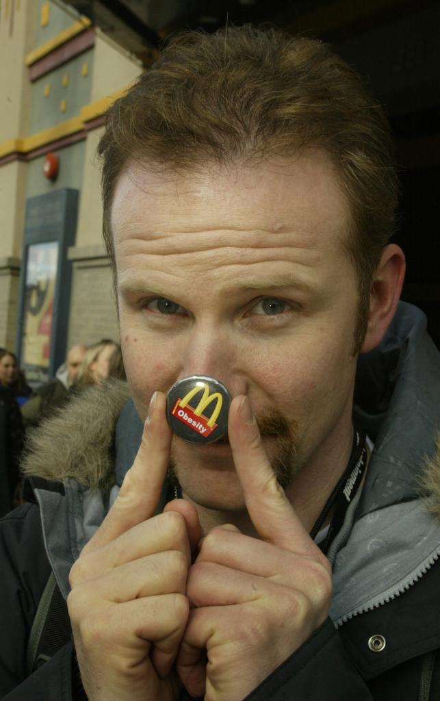 morgan spurlock holding McDonald's pin on his nose