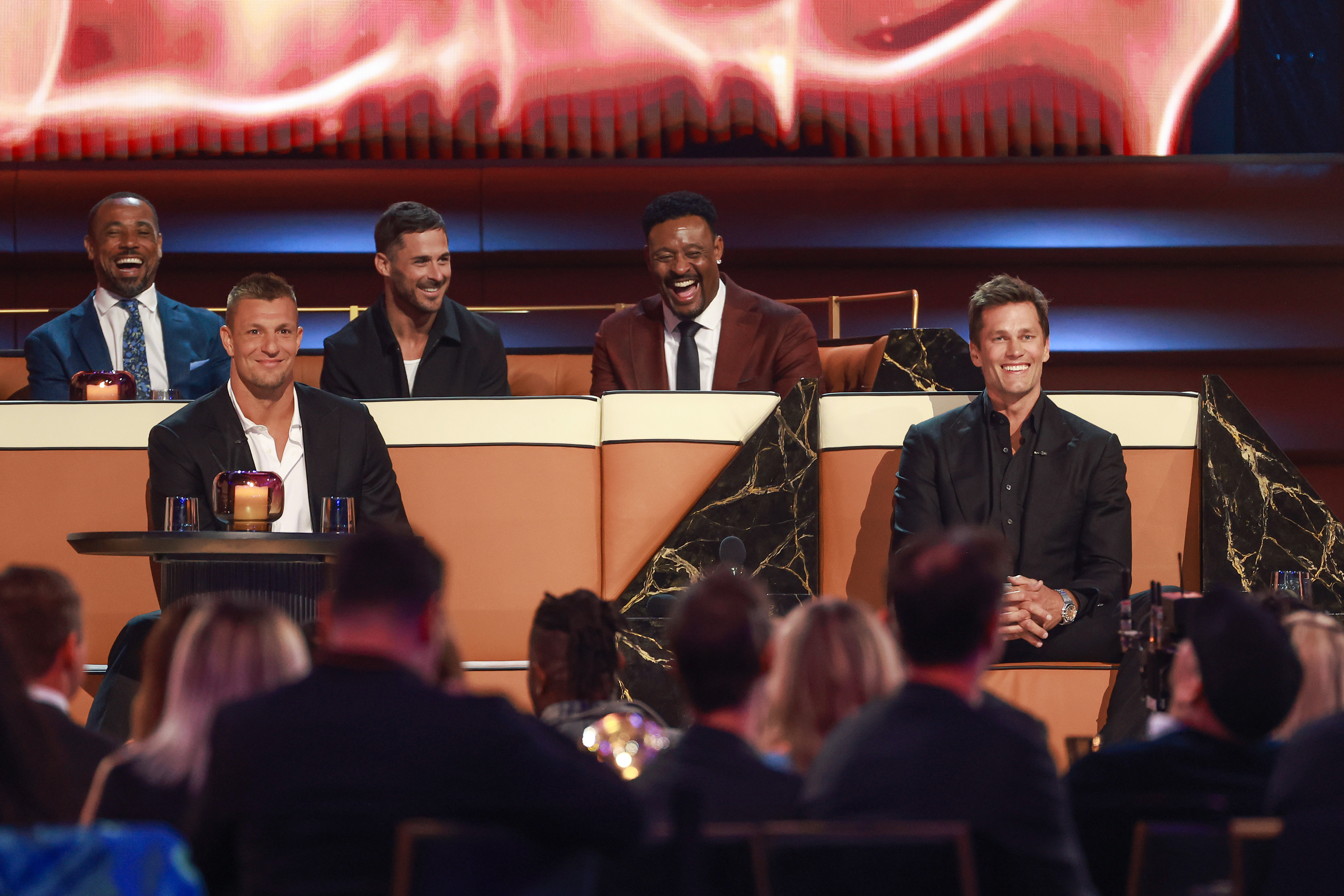 Rob Gronkowski (L) and Tom Brady (R) are seen onstage during sitting together 