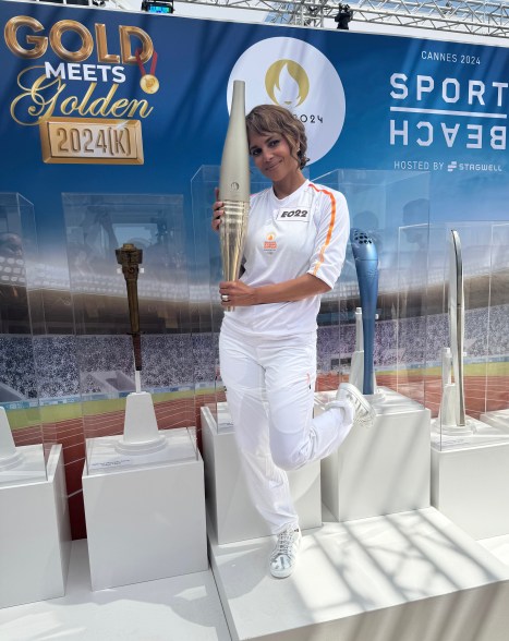 Halle Berry poses with the Paris 2024 Olympic Torch after running the relay in Daniel Essa shoes at Gold Meets Golden at Stagwell Sport Beach in Cannes, France.