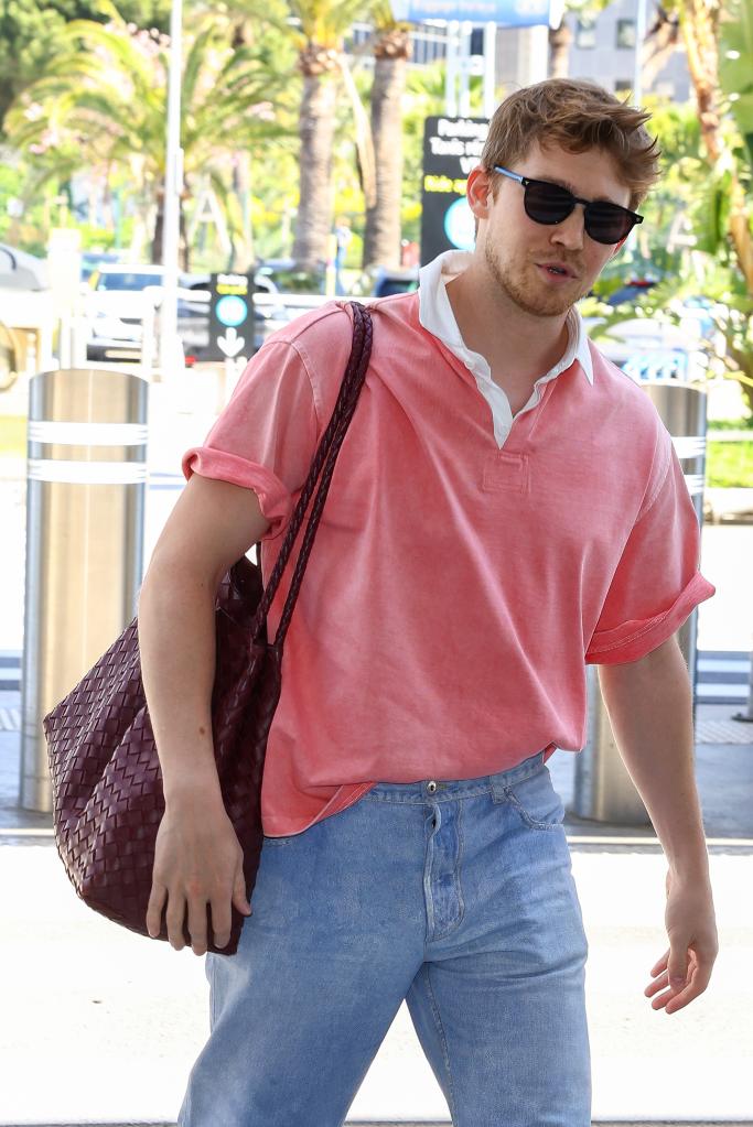 Joe Alwyn in a pink shirt.