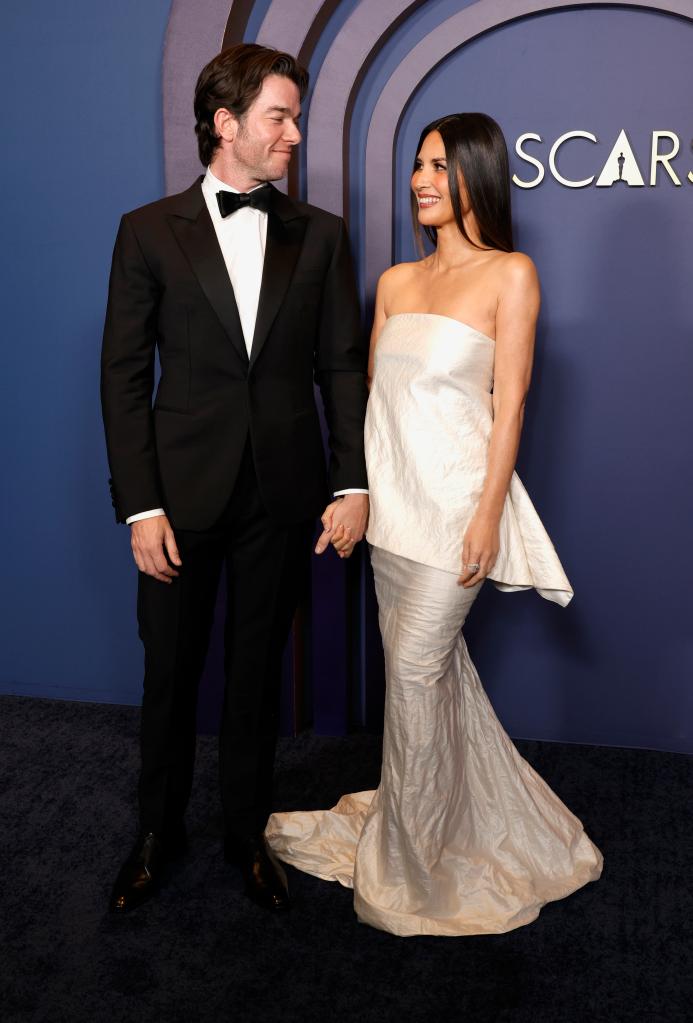 John Mulaney and Olivia Munn on a red carpet. 