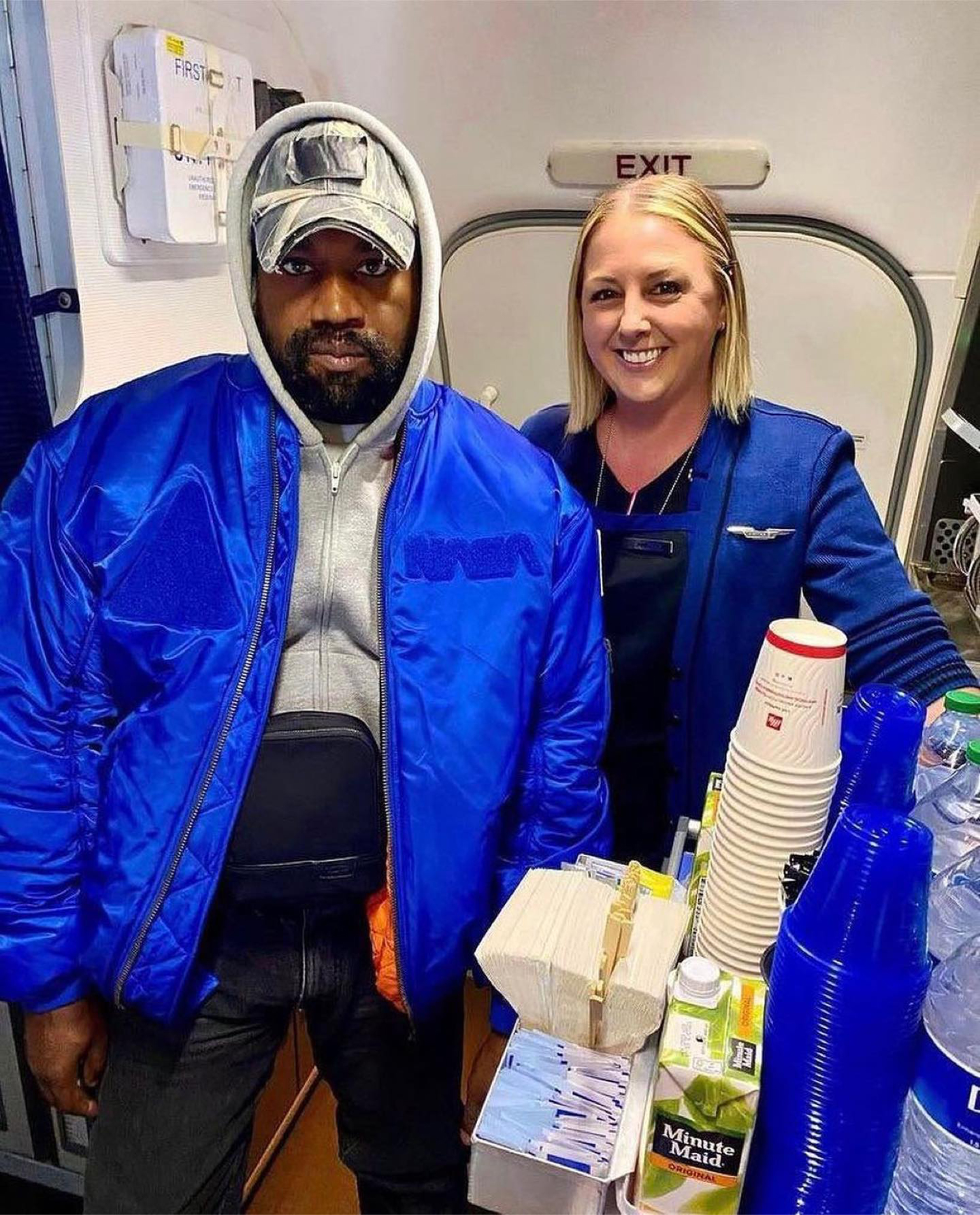 Kanye West posing with a flight attendant.