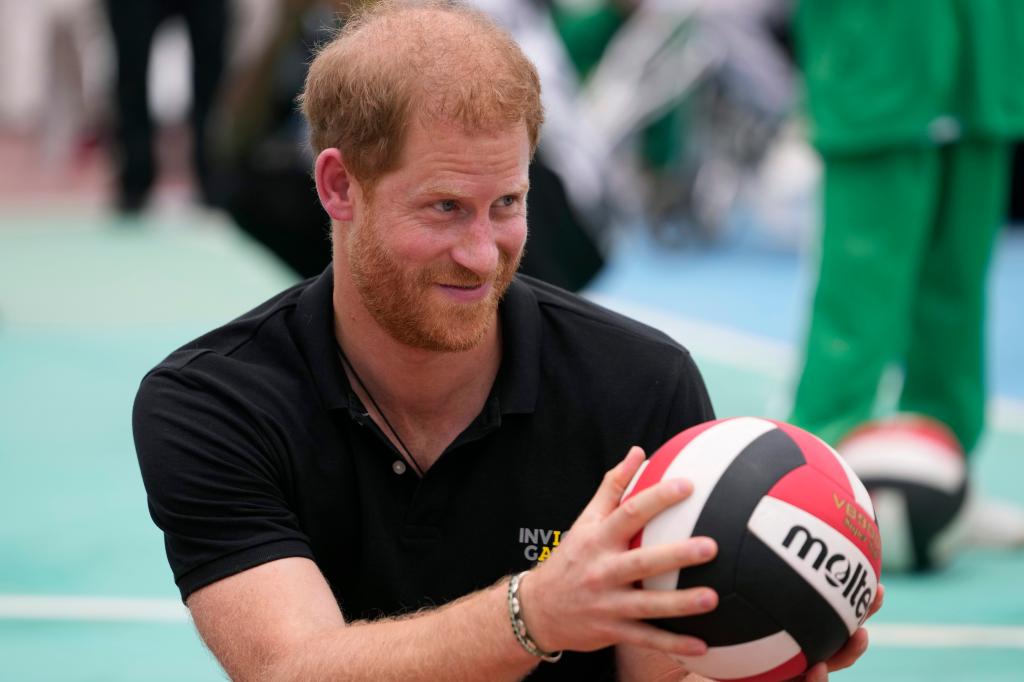 Prince Harry holding a volleyball.