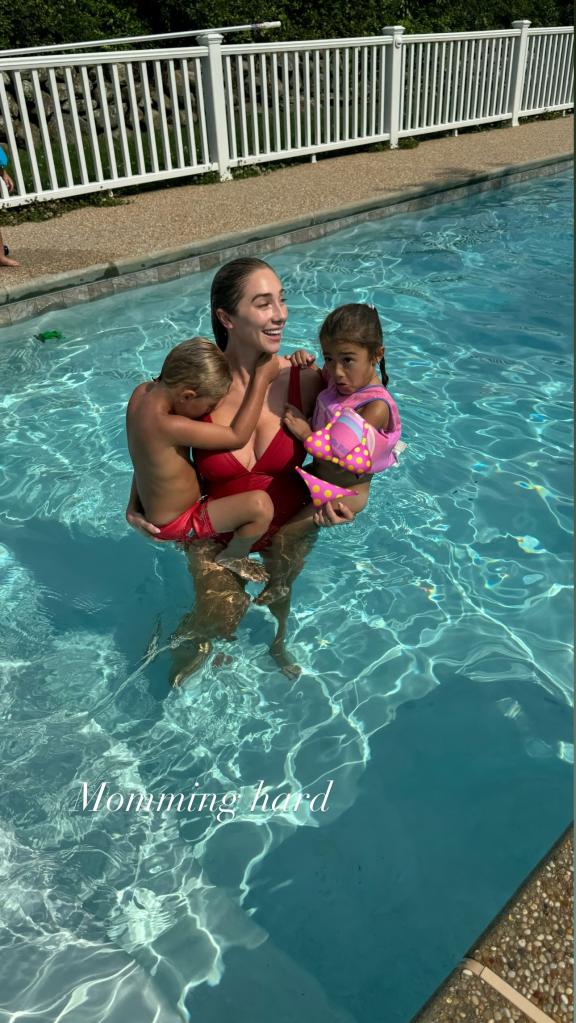 aurora culpo in a pool with her two kids in each arm