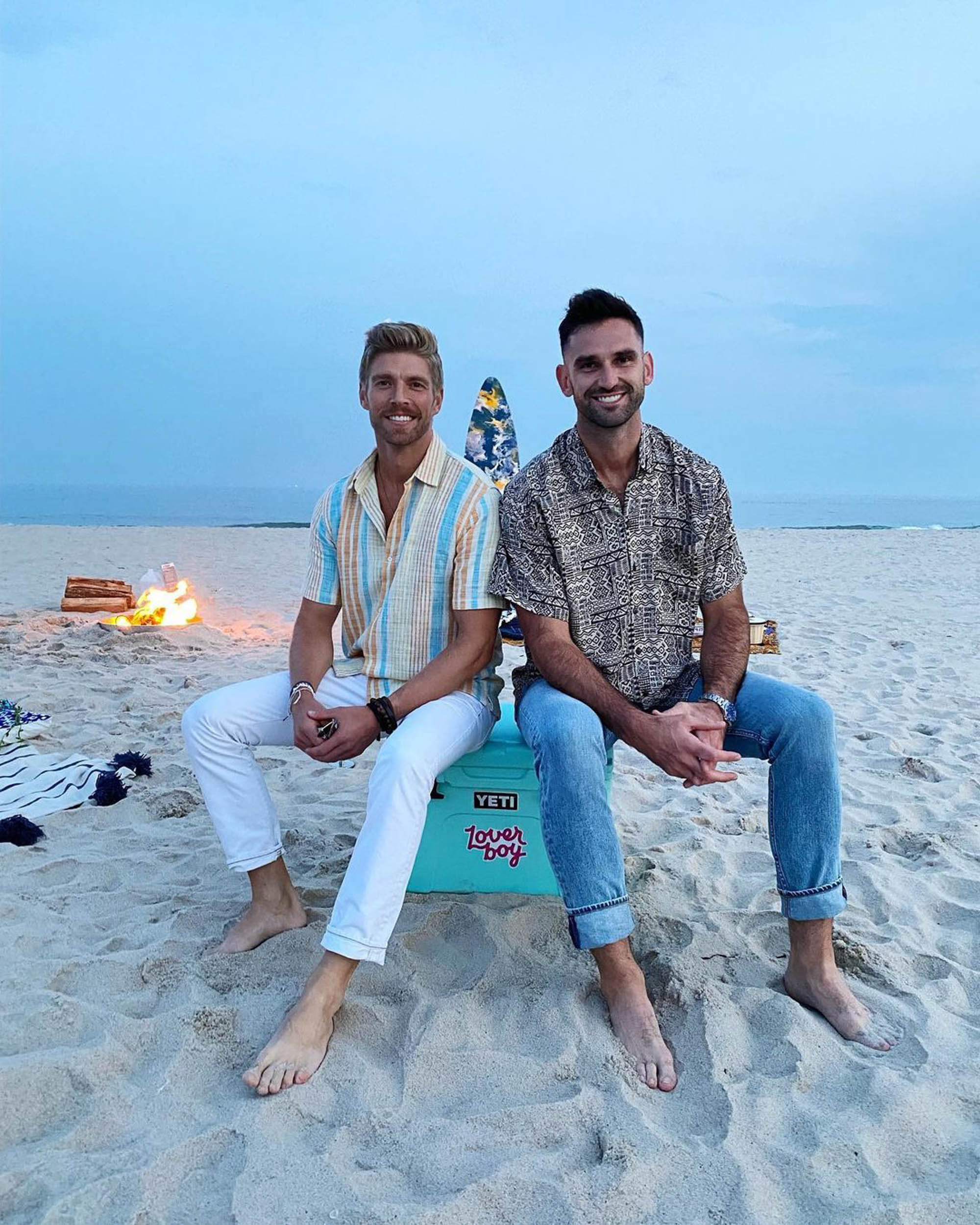 Carl Radke and Kyle Cooke sitting on a beach together 