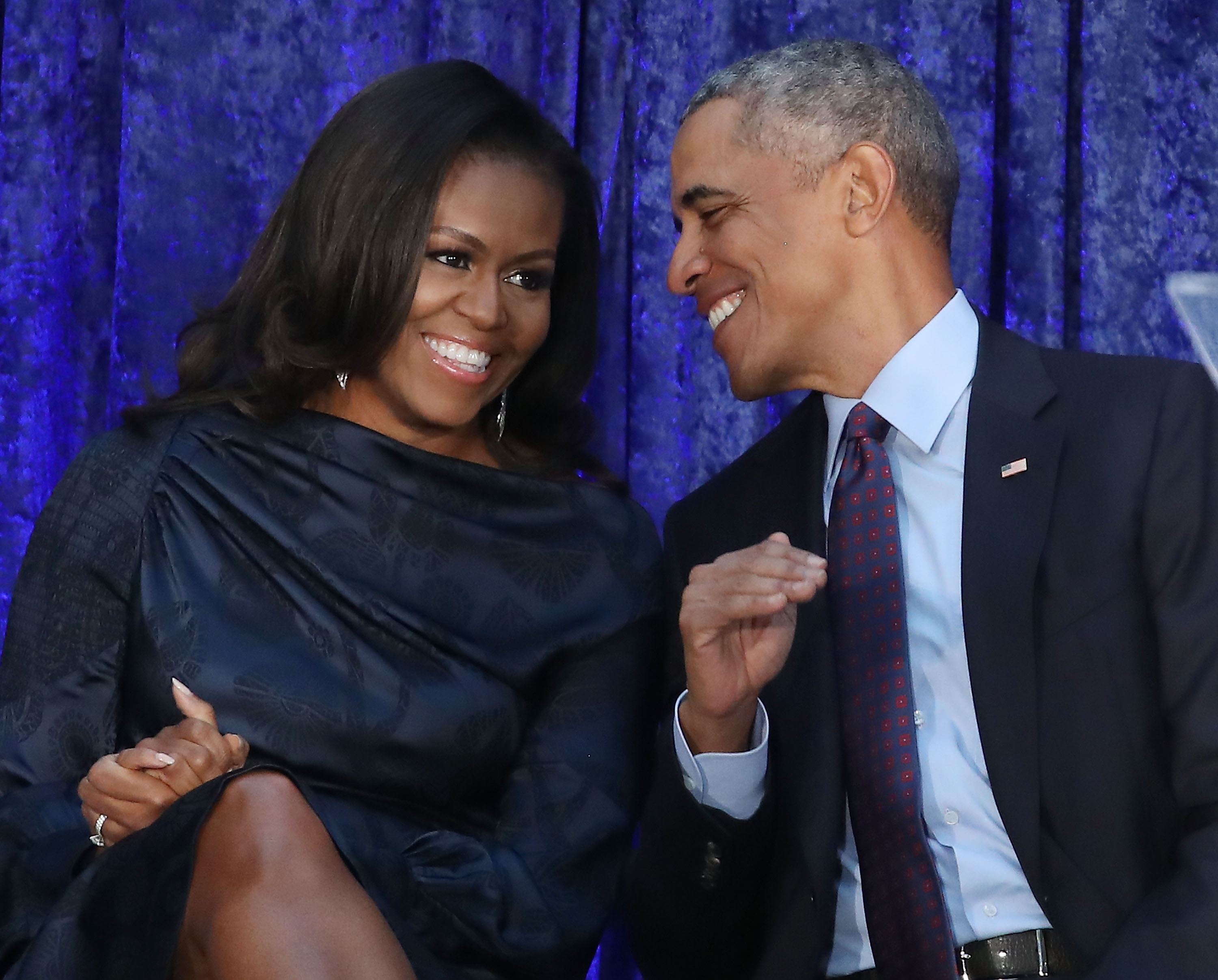 michelle and barack obama sitting and smiling at each other