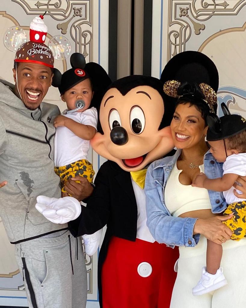nick cannon with two of his kids and one of the mothers of his children with mickey mouse