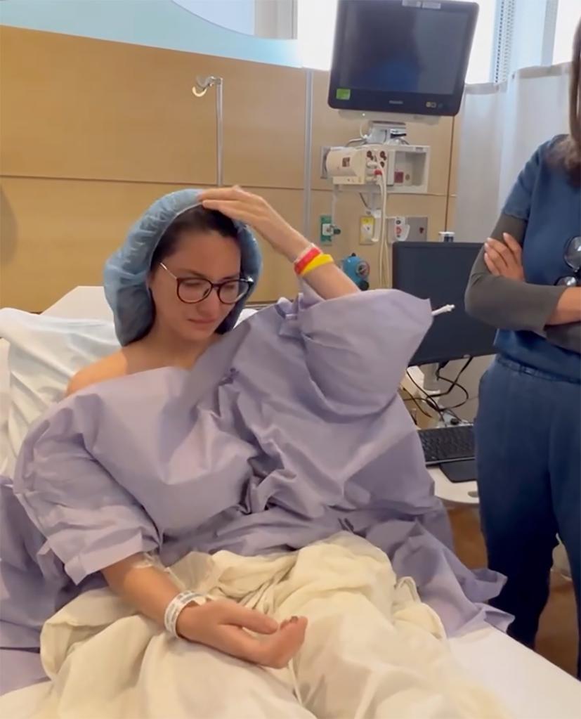 olivia munn adjusting her hair cap in a hospital bed